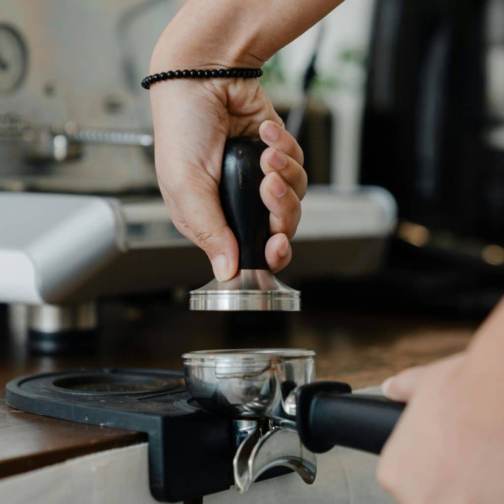 Une personne tampe son café avant extraction
