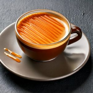 Un café espresso avec un topping caramel salé au-dessus. Image prise en studio