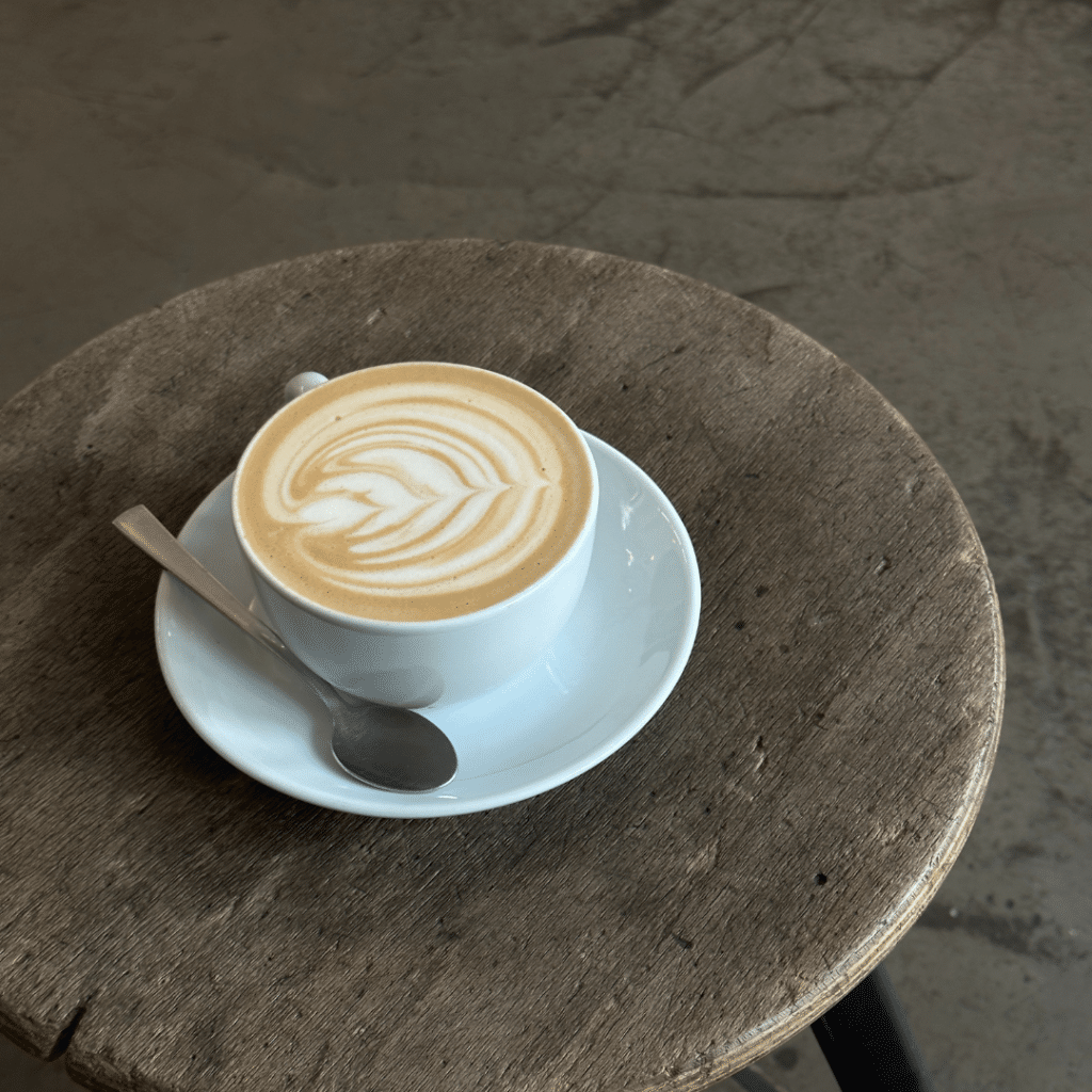 une tasse de cappucino posée sur une table basse en bois