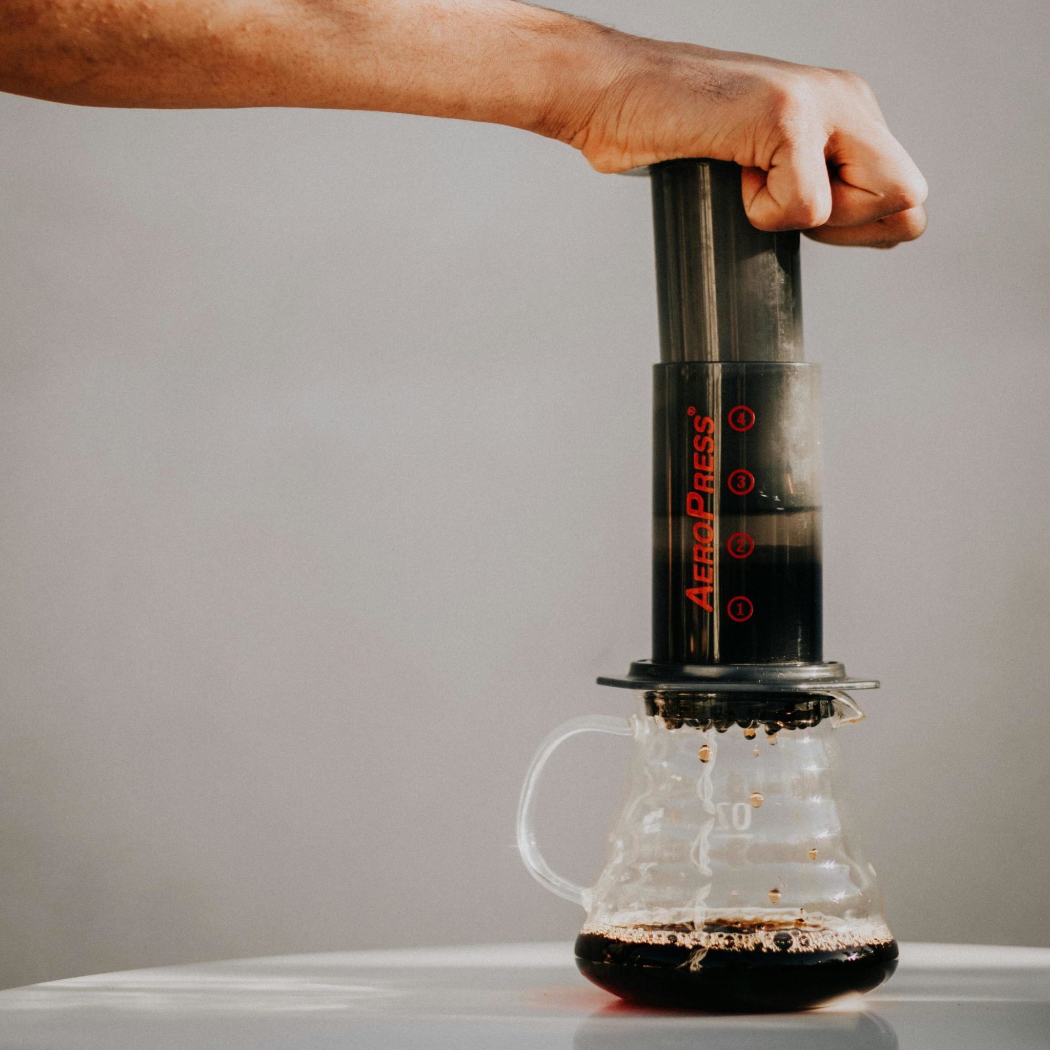 Un homme utilise une Aeropress pour infuser son café
