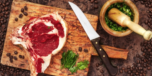 Une cote de boeuf crue avec des épices et des grains de café